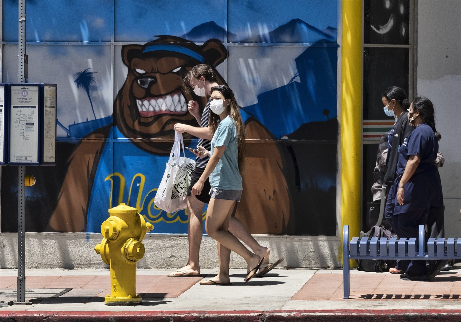 Pedestrians wearing masks walk down the street in the Westwood section of Los Angeles on Friday, May 15, 2020.Richard Vogel / AP