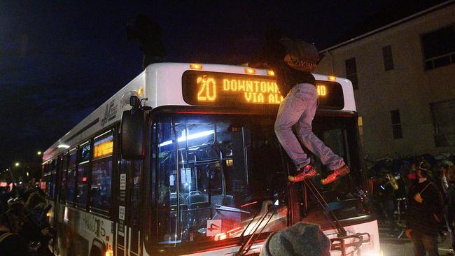 A demonstrator climbs atop a bus in Oakland, California, while protesting the death of George Floyd. Picture: AP/Noah Berger A demonstrator climbs atop a bus in Oakland, California, while protesting the death of George Floyd. Picture: AP/Noah BergerSource:AP