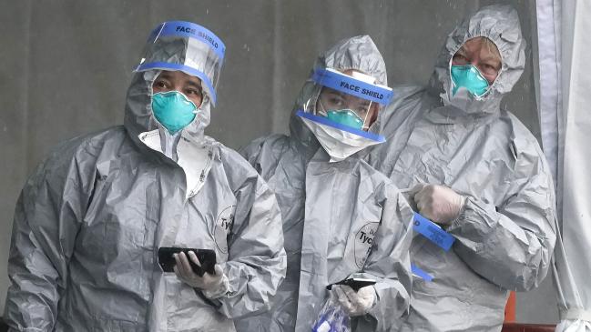 Staff in protective suits wait for people to be tested at a drive through clinic in the US.Source:AFP