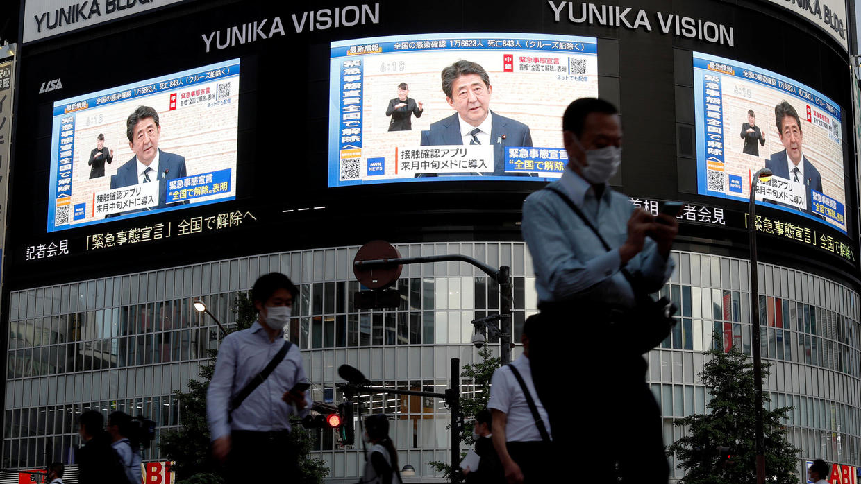 Japanese Prime Minister Shinzo Abe's news conference is broadcast on large screens at Shinjuku district in Tokyo on May 25, 2020. © Issei Kato, REUTERS