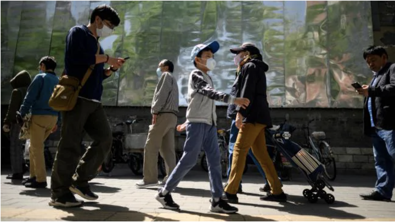  People wearing face masks queue to enter a market in Beijing on May 10. Picture: Noel Celis/AFPSource:AFP