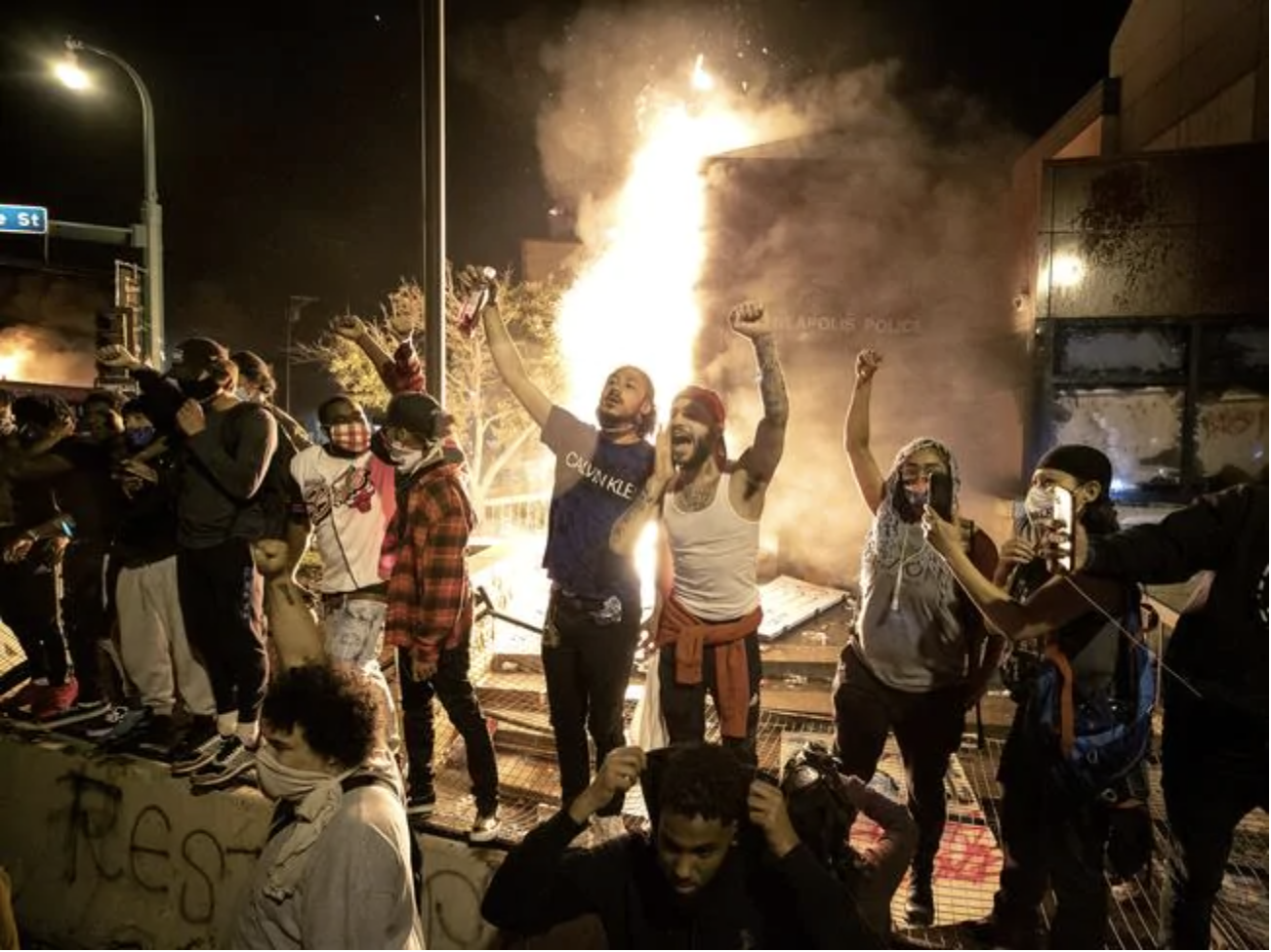  People stand outside the burning 3rd Precinct building. Picture: APSource:AP