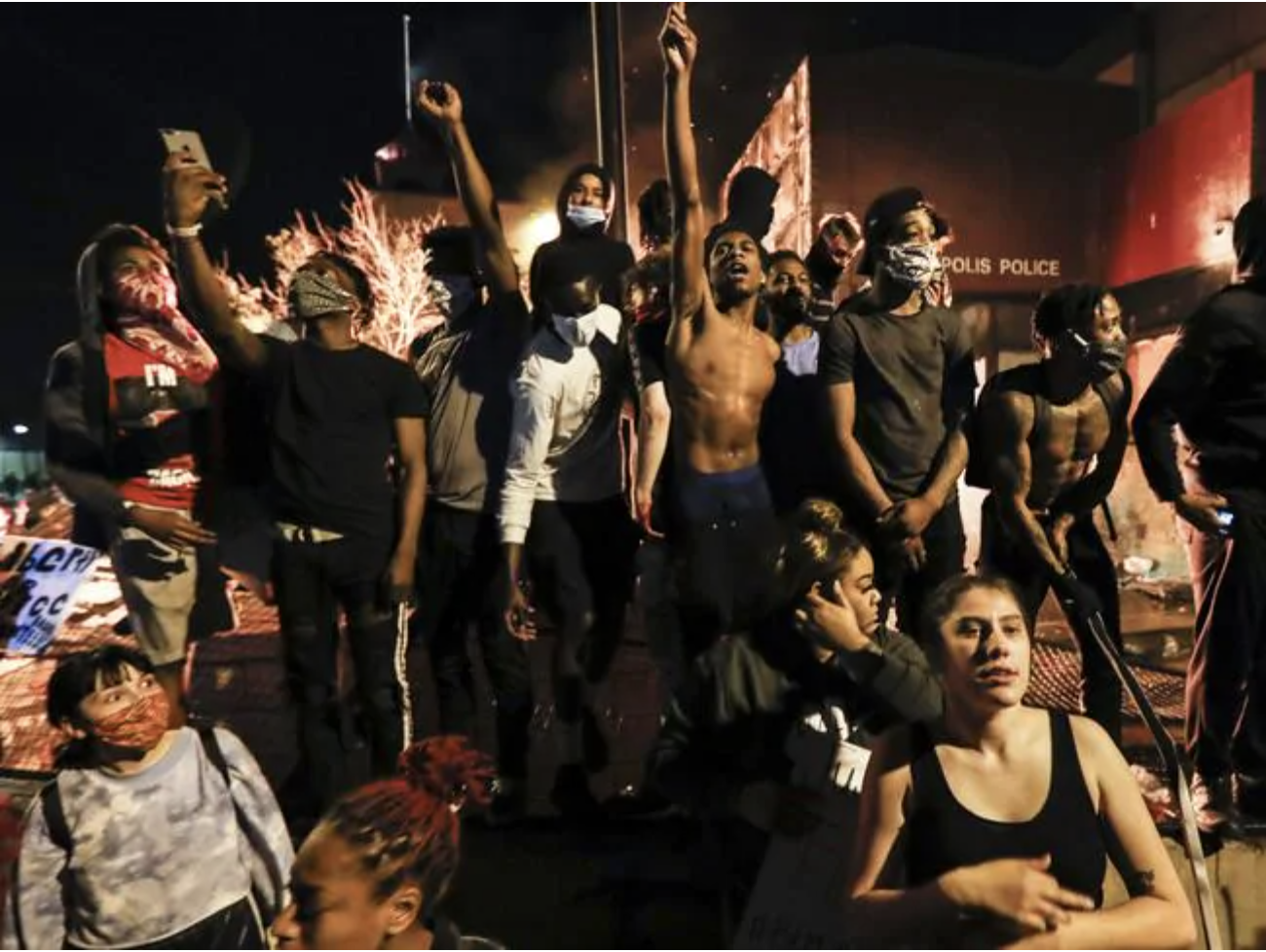 Protesters demonstrate outside of a burning police building over the death of George Floyd, a black man who died in police custody. Picture: AP Photo/John Minchillo. Protesters demonstrate outside of a burning police building over the death of George Floyd, a black man who died in police custody. Picture: AP Photo/John Minchillo.Source:AP