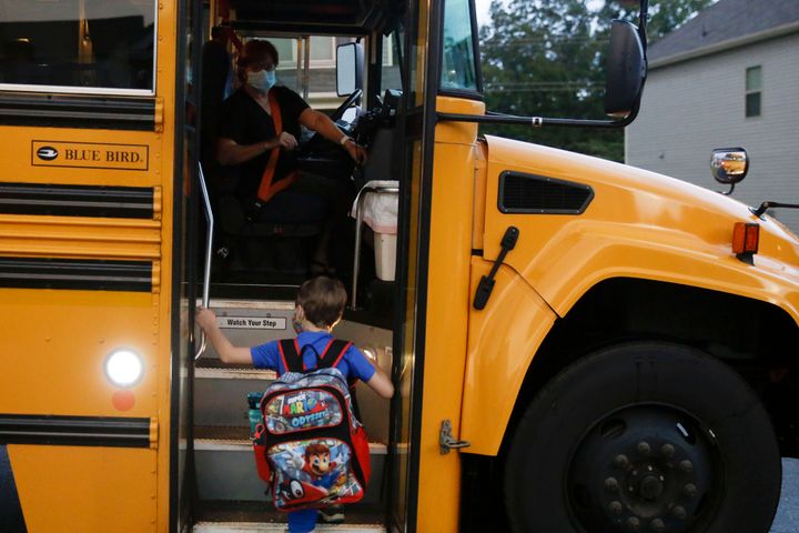 ASSOCIATED PRESS // Paul Adamus, 7, climbs the stairs of a bus before the fist day of school on Monday, Aug. 3, 2020, in Dallas, Ga.  (AP Photo/Brynn Anderson)