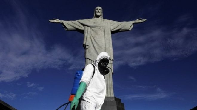 REUTERS / A worker wearing protective clothing stands in front of the Christ the Redeemer statue in Brazil