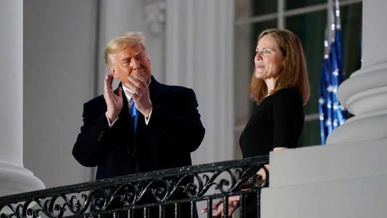 U.S. President Donald Trump applauds Amy Coney Barrett as they stand on the Blue Room Balcony of the White House on Monday. (Patrick Semansky/The Associated Press)