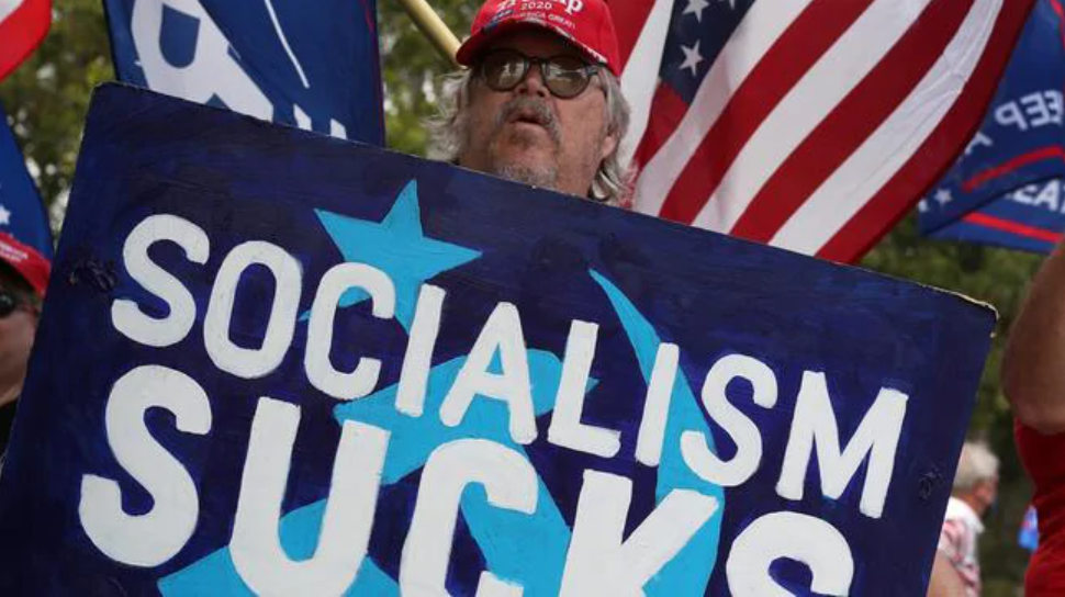 A supporter of Donald Trump holds up a sign saying ‘socialism sucks’ in Florida. Picture: Joe Raedle/Getty Images/AFPSource:AFP