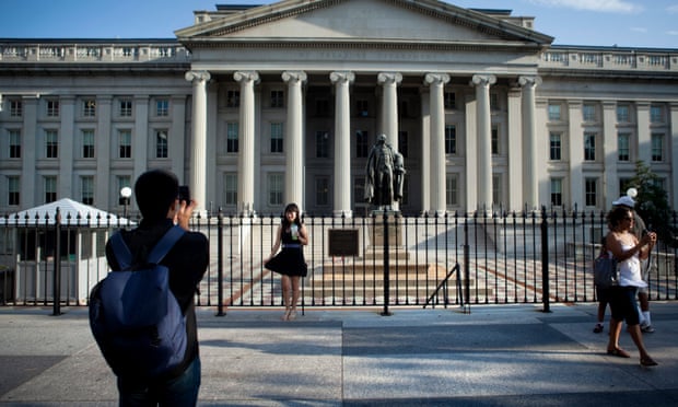 A tourist poses in front of the US treasury department in Washington DC. Photograph: Brendan Smialowski/EPA