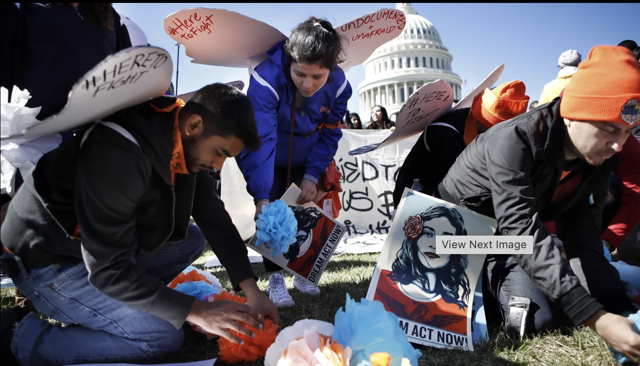 Supporters of the Deferred Action for Childhood Arrivals (DACA) program place paper flowers on the ground in a pattern that spells out the word "unafraid" as they rally in support of DACA recipients on March 5, 2018, on Capitol Hill in W