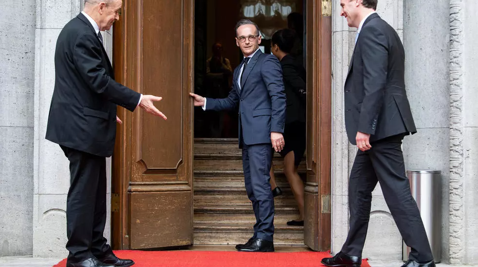 German Foreign Minister Heiko Maas (C) and his French counterpart Jean-Yves Le Drian (L) welcome Britain's Secretary of State Dominic Raab (R) arriving for talks in Berlin on June 19, 2020. © Bernd von Jutrczenka, AFP