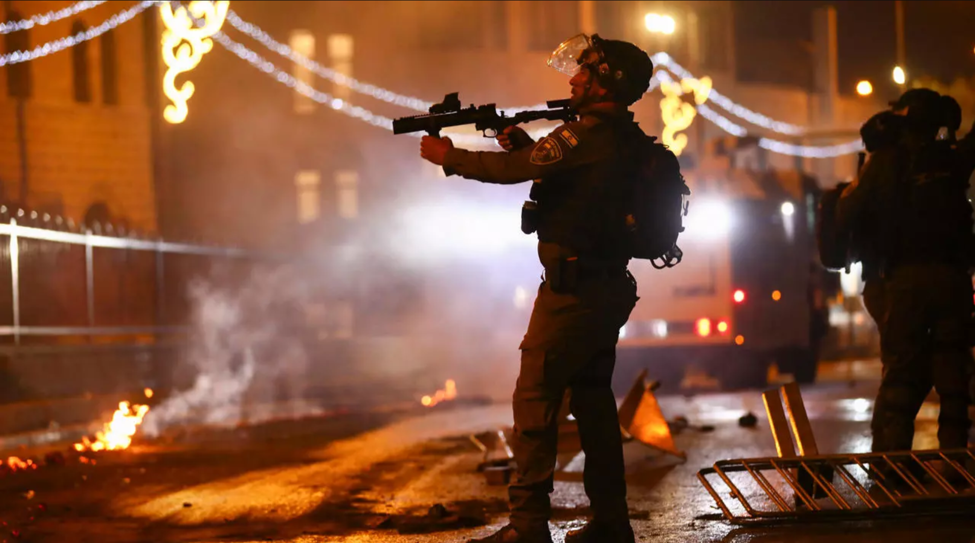 An Israeli police officer aims his rifle towards Palestinian demonstrators during clashes at Damascus Gate just outside Jerusalem's Old City, on May 8, 2021. © Oded Balilty, AP