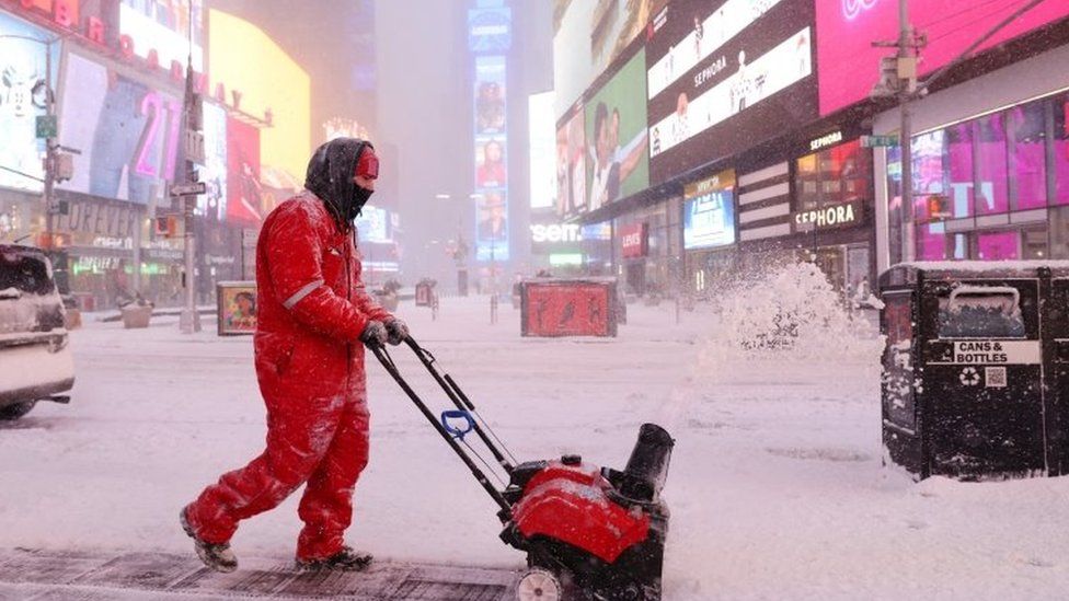 A worker clears snow in Times Square / ,REUTERS, New York officials have told people to stay home and wait the storm out