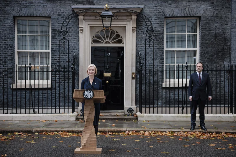 Prime Minister Liz Truss delivers her resignation speech as her husband, Hugh O'Leary, stands nearby at Downing Street in London on Thursday. Truss has been prime minister for just 44 days. Rob Pinney/Getty Images
