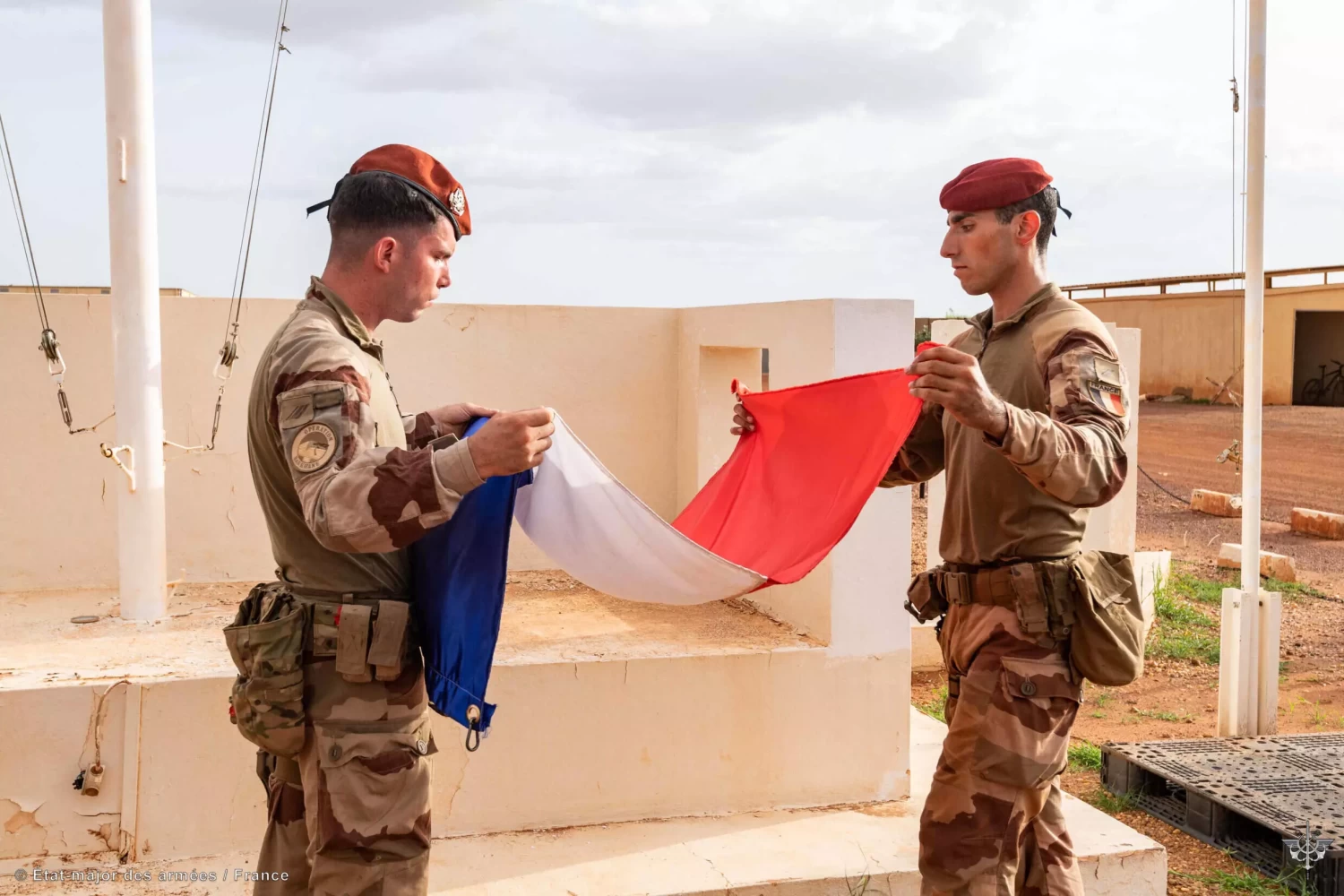Soldiers of the “Barkhane” military mission in the Sahel fold a French flag at an undisclosed military installation amid the French military drawdown with troops leaving the last bases in Mali in this handout photograph taken on August 11, 2022 and released by the Etat Major des Armées. © French Defence Staff, AFP