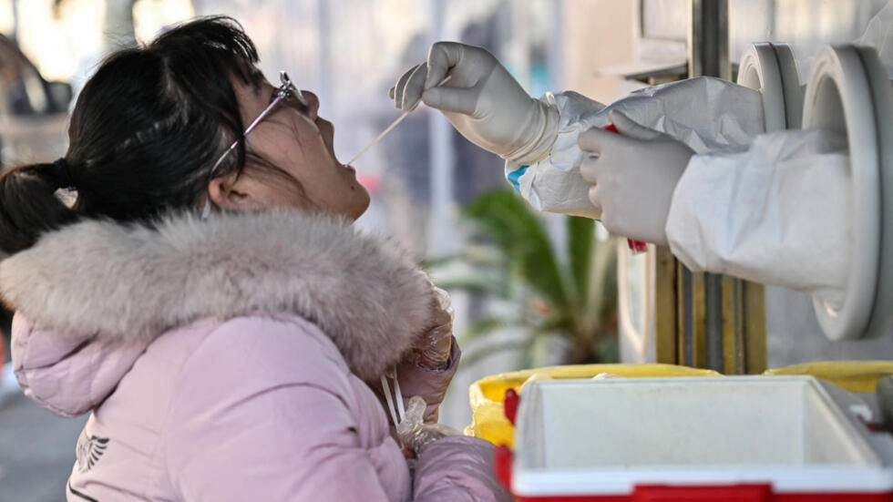 A health worker takes a swab sample from a woman to test for Covid-19 in the Jing'an district in Shanghai on December 22, 2022. © Hector Retamal, AFP