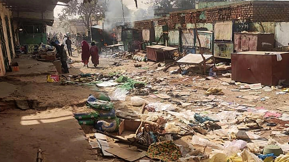 People walk among scattered objects in the market of El Geneina, the capital of West Darfur, as fighting continues in Sudan between the forces of two rival generals, on April 29, 2023. © AFP