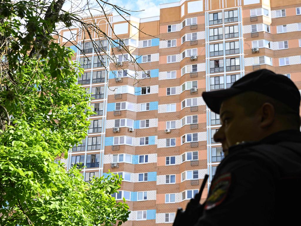 A police officer stands guard outside a multistorey apartment building after a reported drone attack in Moscow on May 30, 2023.