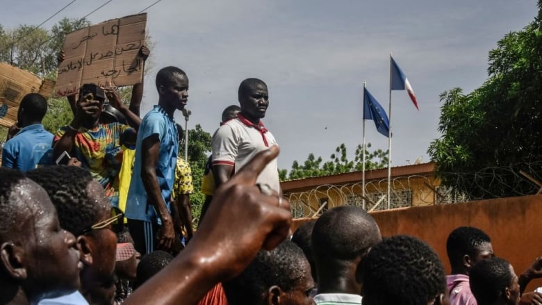 Protesters gather on Sunday in front of the French Embassy in Niger's capital, Niamey, during a demonstration that followed a march in support of last week's military takeover in the West African country. (AFP/Getty Images)