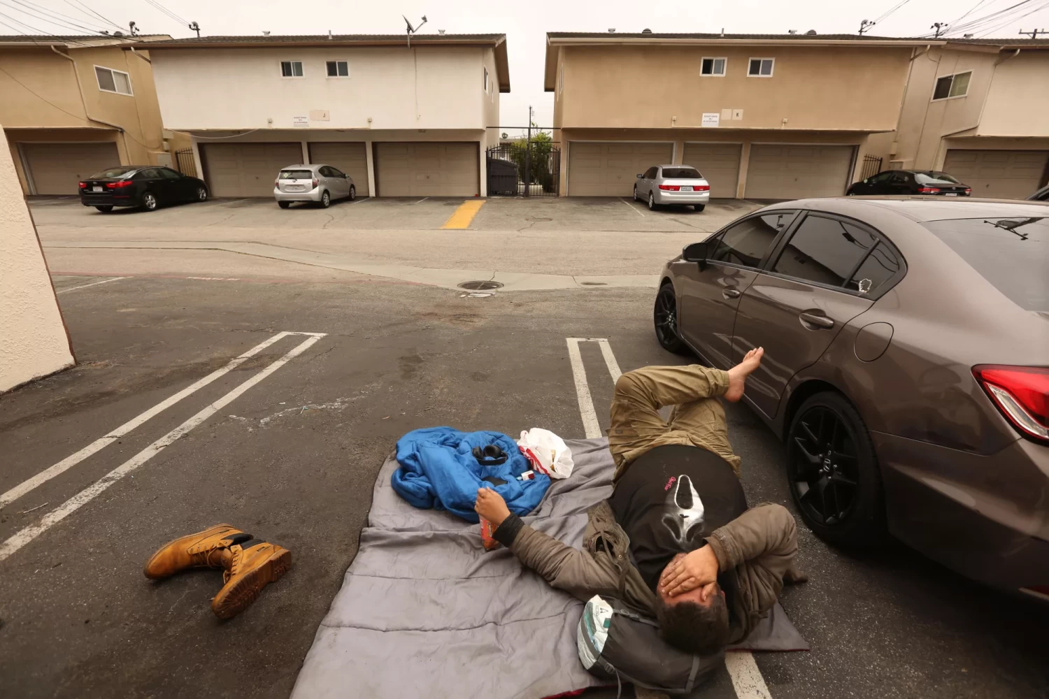 Andrew Truelove rests on a sleeping bag in a parking lot in Torrance on May 23.(Genaro Molina / Los Angeles Times)
