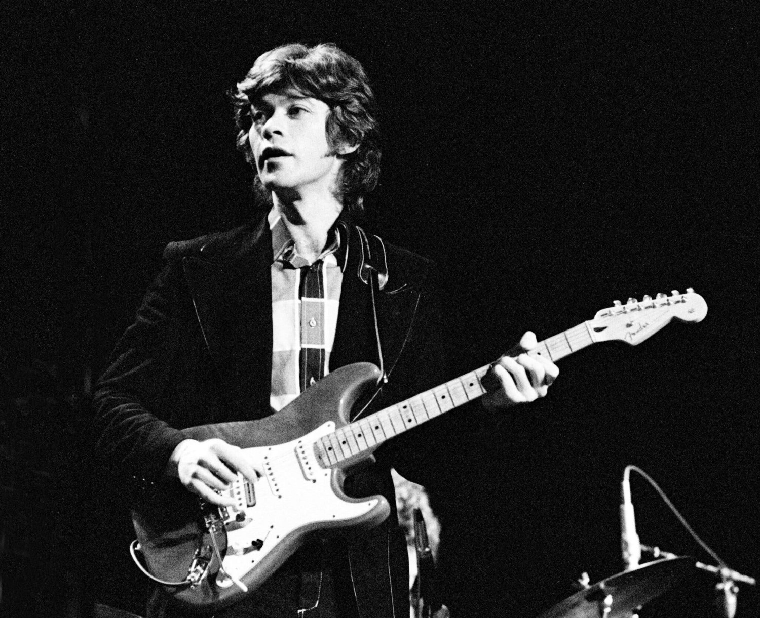 Robbie Robertson in performance with the Band in 1971. The group, for which he was the main songwriter and lead guitarist, helped inspire the Americana genre.Credit...Gijsbert Hanekroot/Redferns