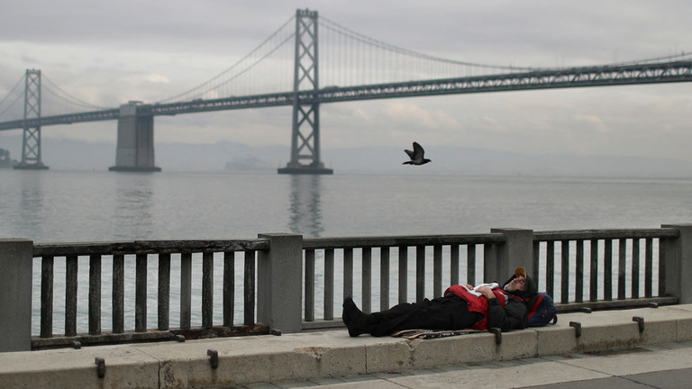 FILE PHOTO: A homeless man sleeps on the sidewalk near the San Francisco Oakland Bay Bridge ©  JUSTIN SULLIVAN / GETTY IMAGES NORTH AMERICA / GETTY IMAGES VIA AFP