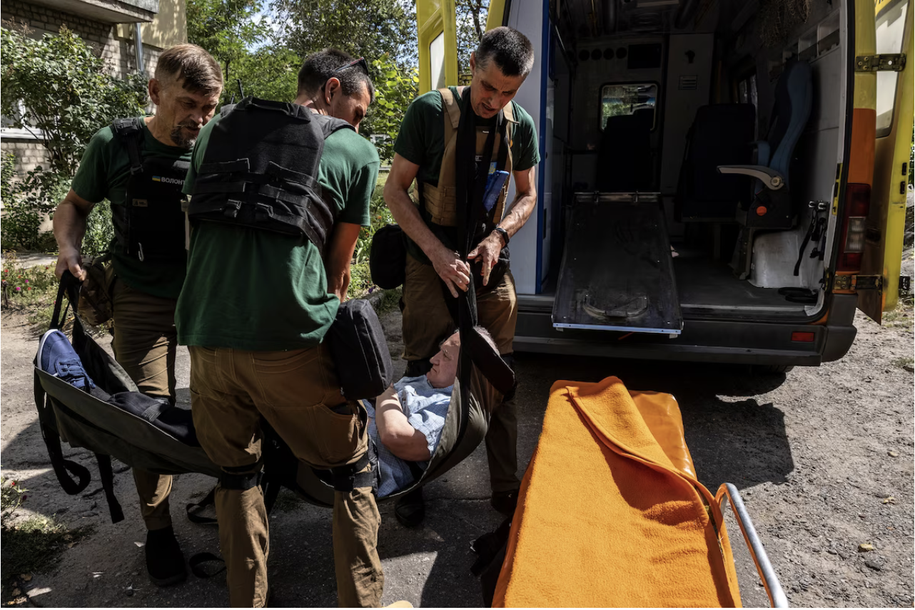  Volunteers used a tarp to carry Oleksandr downstairs to a waiting ambulance. (Heidi Levine for The Washington Post)