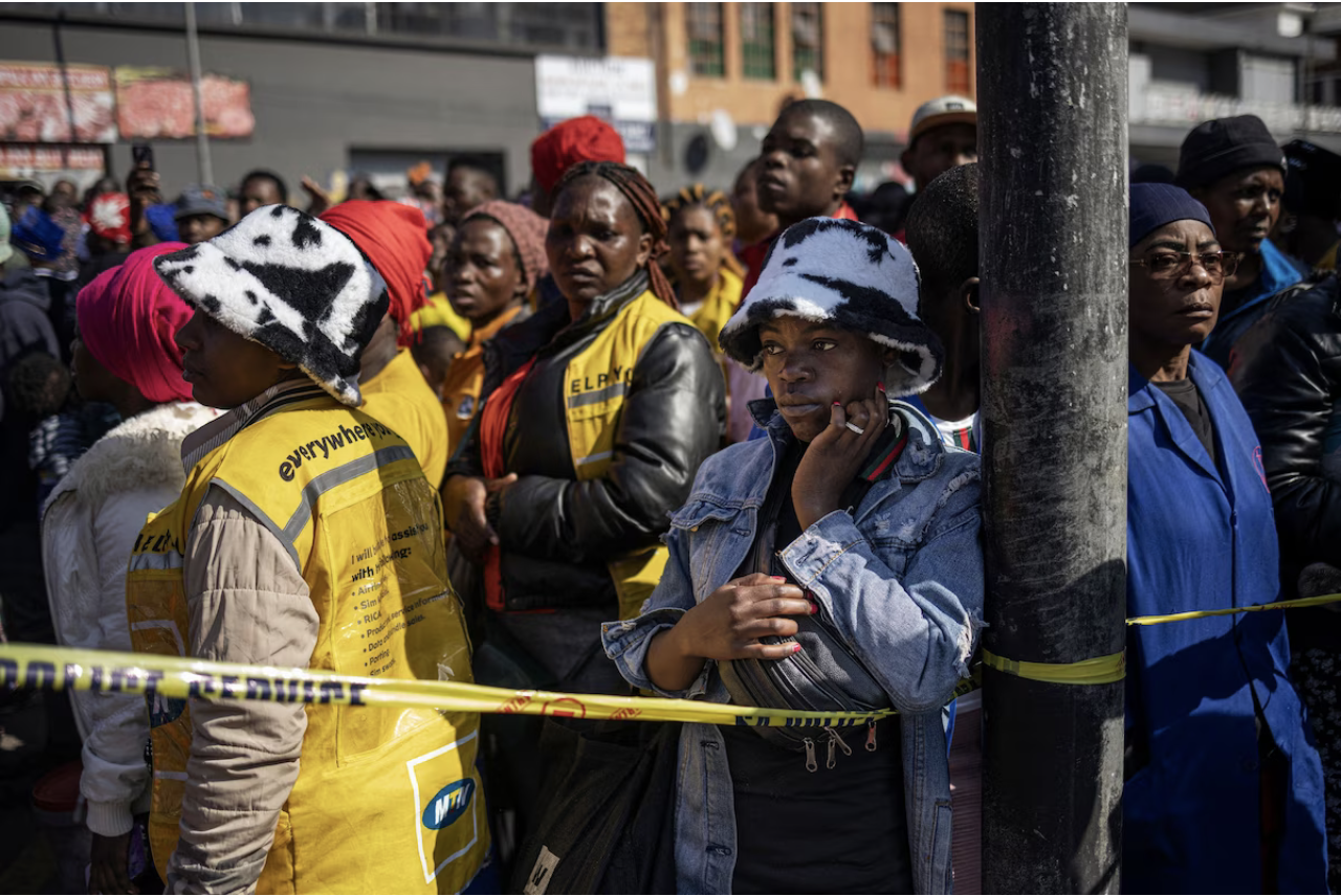 People watch as firefighters work at the scene of a burned-out apartment block in central Johannesburg on Thursday. (Michele Spatari/AFP/Getty Images)