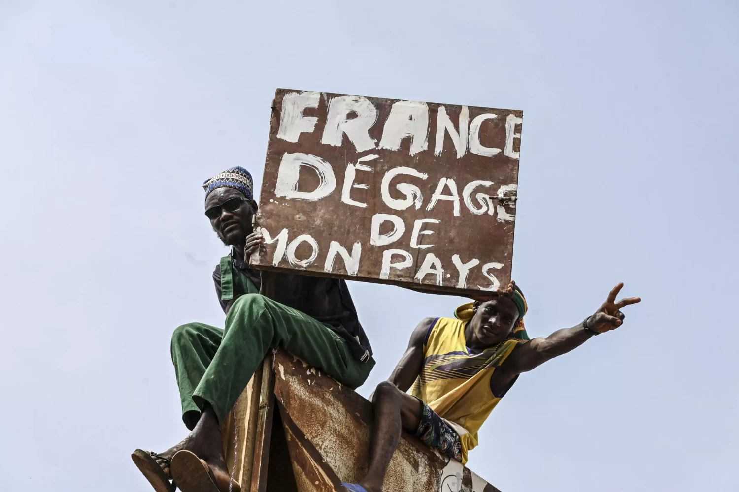 A man holds a placard reading 'France get out of my country'. © AFP