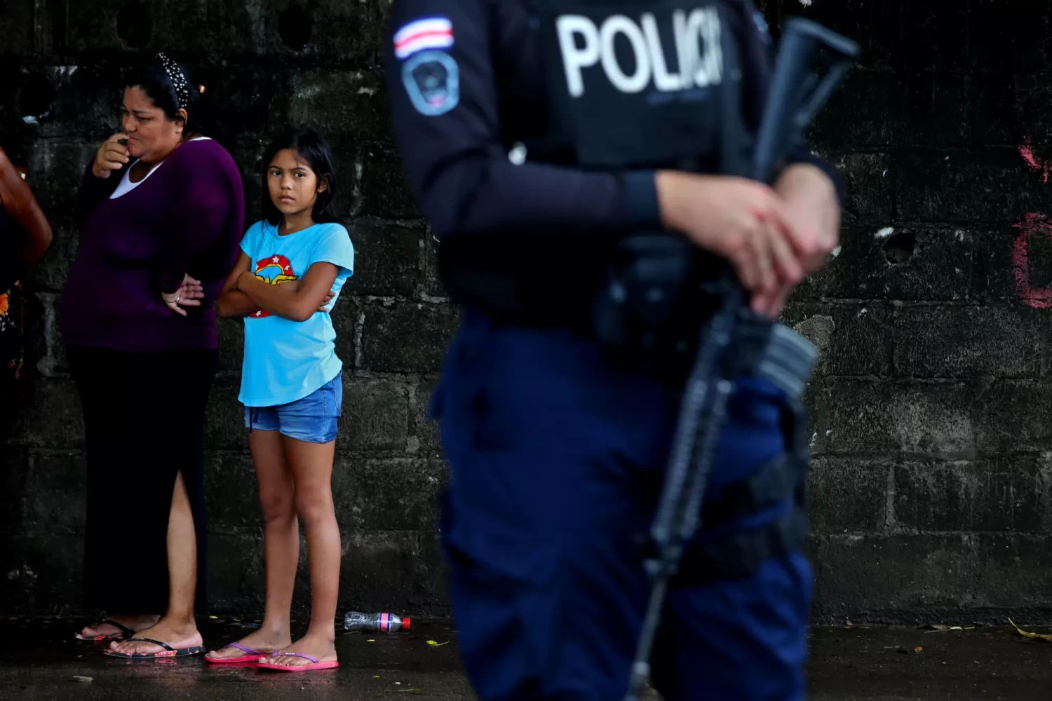 A young girl takes in a police roadblock in Chacarita, Costa Rica, where violence has skyrocketed in recent years. (Gary Coronado / Los Angeles Times)