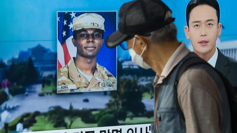 A man walks past a television showing a news broadcast featuring a photo of US soldier Travis King, who ran across the border into North Korea on July 18, 2023. ©  Anthony WALLACE / AFP