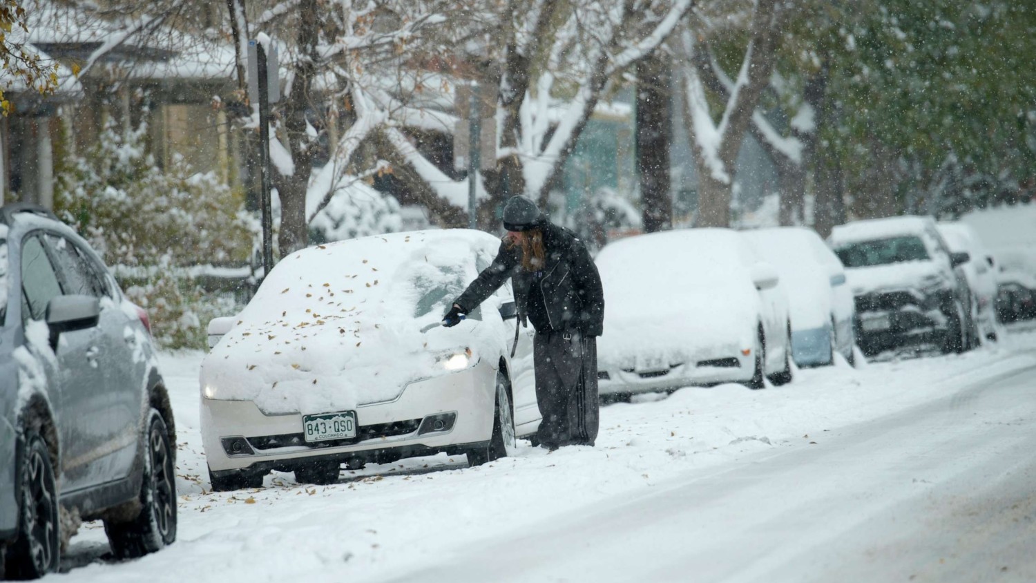 A motorist clears snow from a vehicle after a winter storm dumped up to a foot of snow in some Front Range communities, Oct. 29, 2023, in Denver. David Zalubowski/AP
