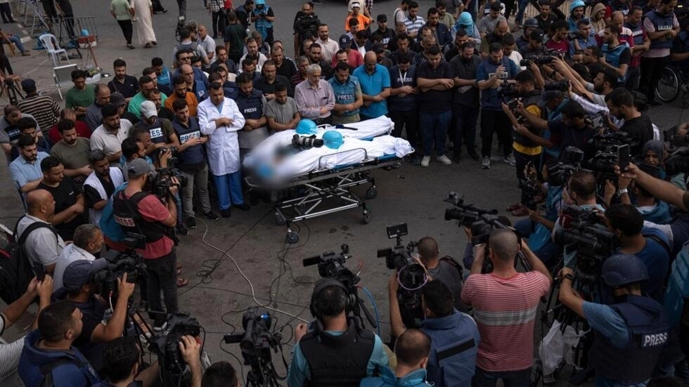 Des Palestiniens, principalement des journalistes, rassemblés autour des corps de deux reporters palestiniens, Mohammed Soboh et Said al-Tawil, tués par une frappe aérienne israélienne à Gaza, le 10 octobre 2023. © AP, Fatima Shbair