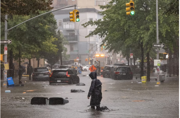 A person walks on a flooded street during heavy rain in Brooklyn on Sept. 29. (Yuki Iwamura for The Washington Post)