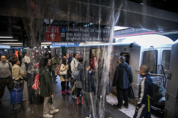Commuters wait at a subway station during a rainstorm in Brooklyn on Sept. 29. Multiple New York City subway lines were shut and streets inundated after torrential rain drenched the area. (Michael Nagle/Bloomberg News)