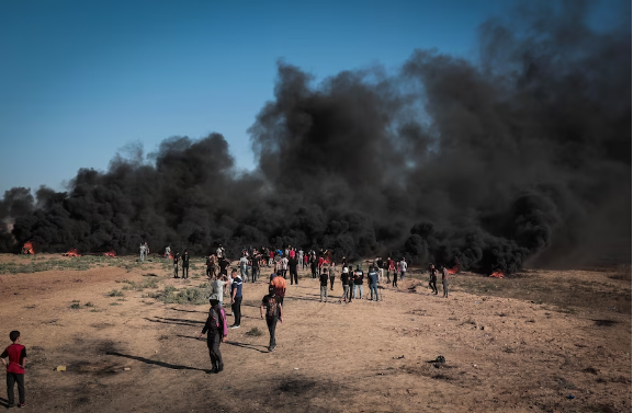 Palestinian demonstrators burn rubber tires along the border fence east of Gaza City on Sept. 15. (Loan Ayyoub for The Washington Post)