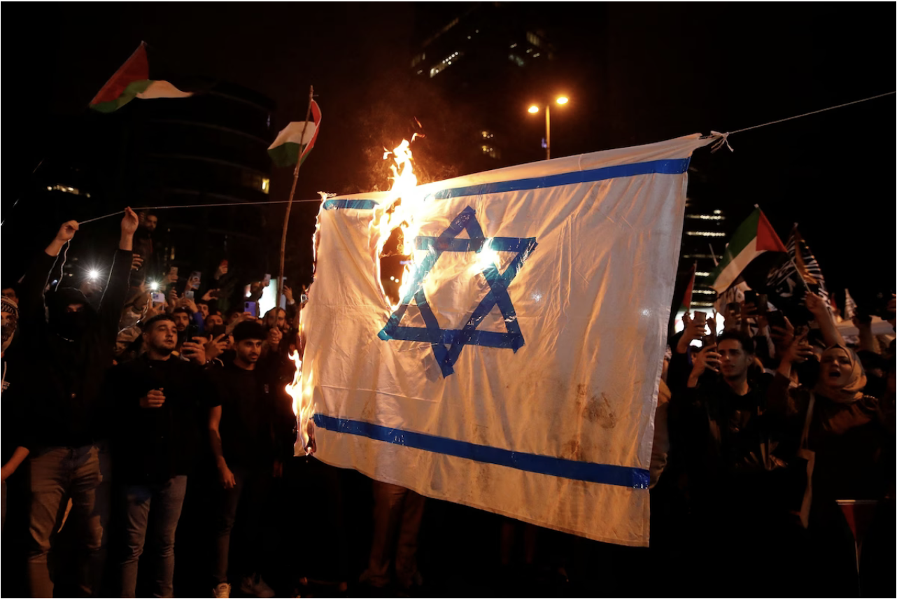 Demonstrators set fire to a makeshift Israeli flag near the Israeli Consulate in Istanbul on Wednesday. (Dilara Senkaya/Reuters)