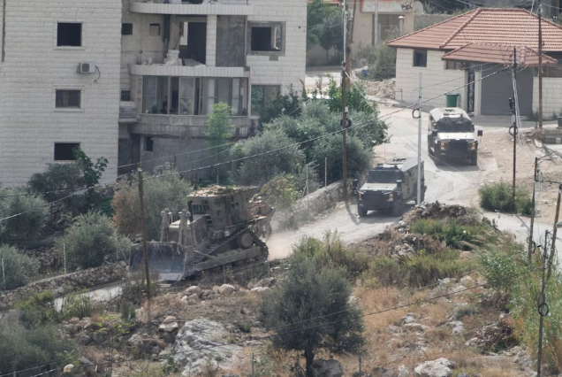 Israeli military vehicles conduct a raid on the Nur Shams refugee camp in the West Bank on Thursday. (Majdi Mohammed/AP)