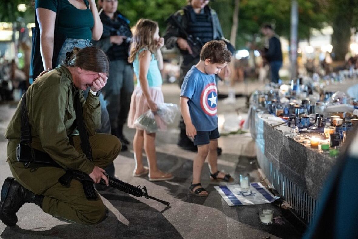 People gather and light candles Sunday in Tel Aviv to remember the victims who were killed by Hamas militants on Oct. 7. (Dima Vazinovich/AFP/Getty Images)