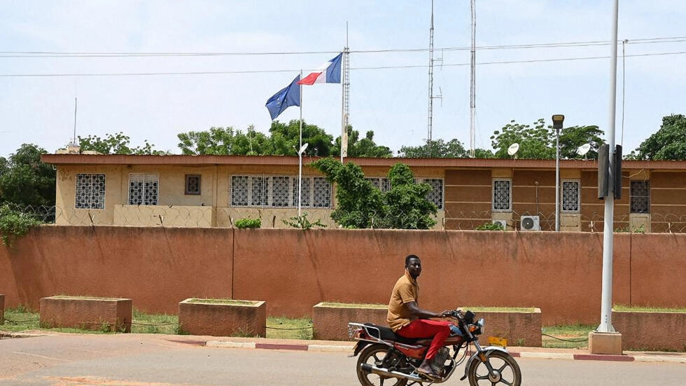 A man rides his motorbike past the French Embassy in Niamey on August 28, 2023. © AFP