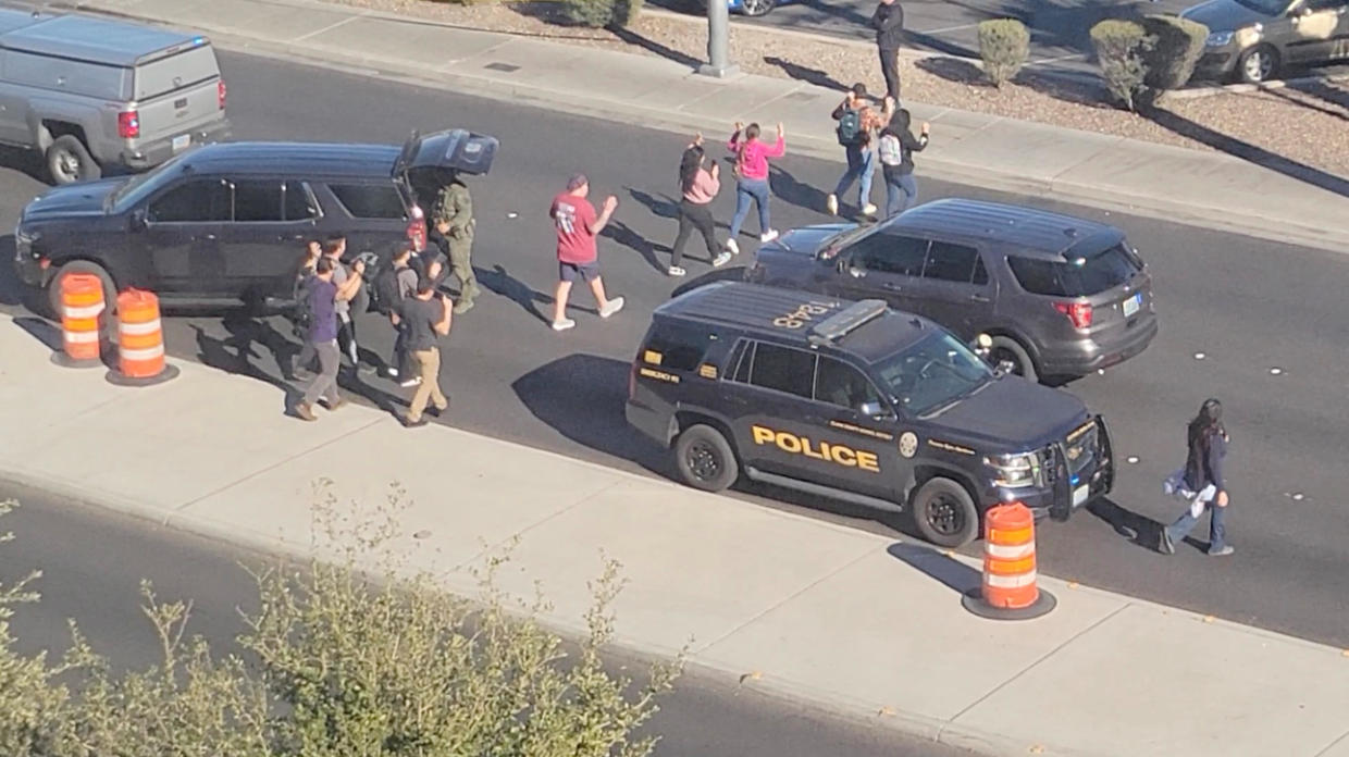People leave campus with raised hands following reports of a shooting at the University of Nevada campus of Las Vegas, Dec. 6, 2023. FROM VIDEO OBTAINED BY REUTERS