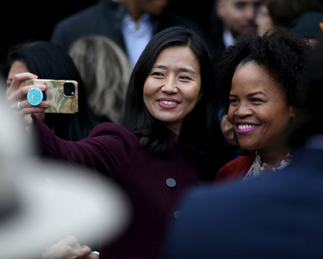 Boston Mayor Michelle Wu takes a selfie with former city mayor Kim Janey after the unveiling ceremony of "The Embrace," a sculpture dedicated to Rev. Martin Luther King Jr. and Coretta Scott King on Boston Common, Friday, Jan. 13,  2023.