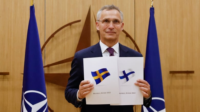 NATO Secretary General Jens Stoltenberg displays documents as Sweden and Finland apply for membership in Brussels, Belgium, on May 18, 2022. Finland has since joined, while Sweden is still waiting. (Johanna Geron/The Associated Press)