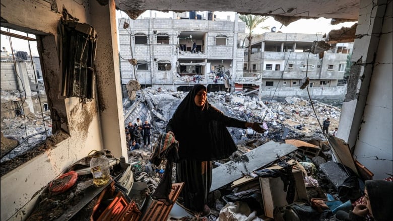 People inspect a destroyed building where Palestinian journalist Adel Zorob was killed overnight by Israeli bombardment of the city of Rafah in the southern Gaza Strip Tuesday. (Mahmud Hams/AFP/Getty Images)