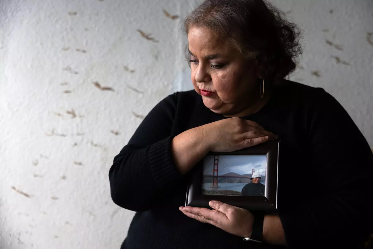 Sandra Muñoz holds a photo of her husband, Luis Acensio Cordero, who was denied his visa, in part, over his tattoos. (Francine Orr / Los Angeles Times)