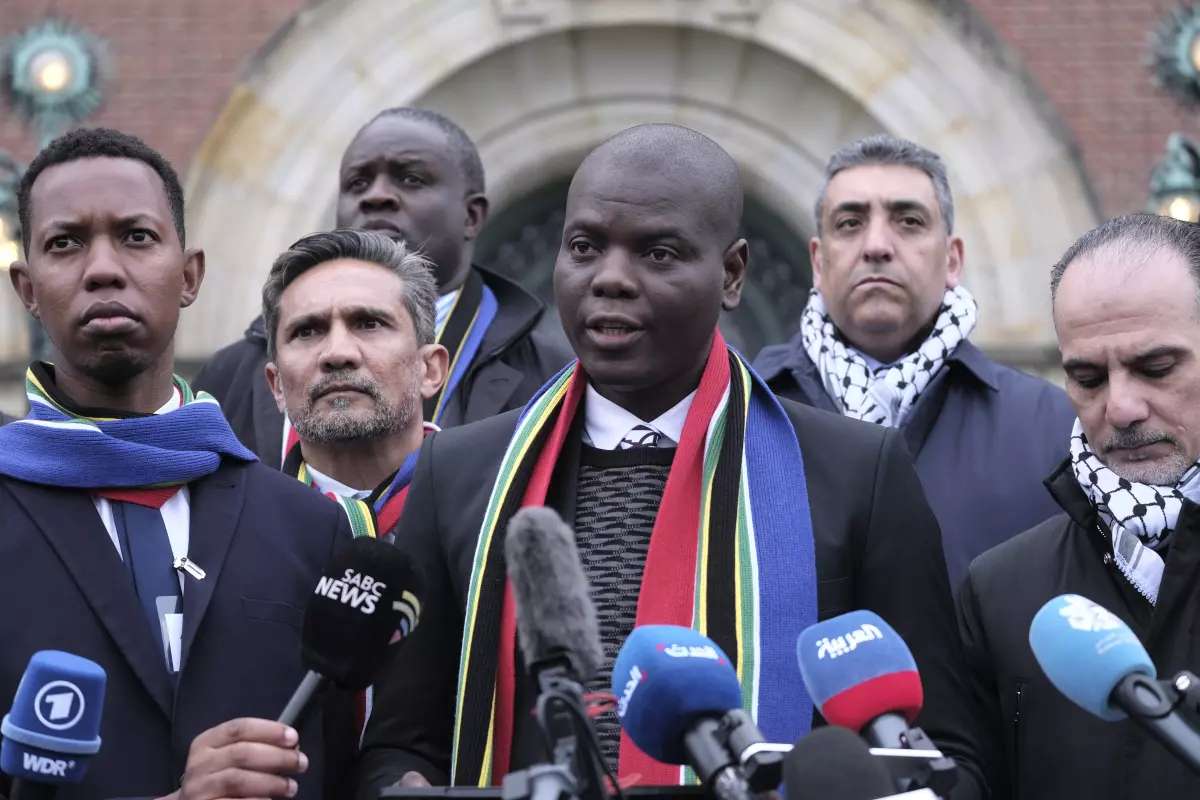 Ronald Lamola, center, South Africas minister of justice, stands with Ammar Hijazi, right, the Palestinian assistant minister of multilateral affairs, outside the International Court of Justice in The Hague on Jan. 11. Patrick Post  Associated Press