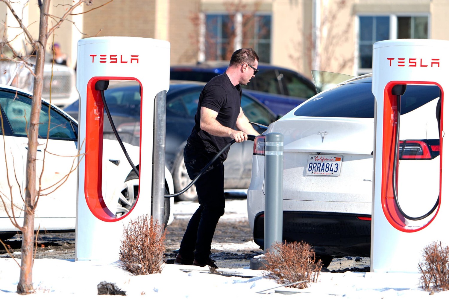 A driver charging his car in Denver on Tuesday. Tesla drivers across the United States have struggled with severely cold weather this week. Credit...David Zalubowski/Associated Press