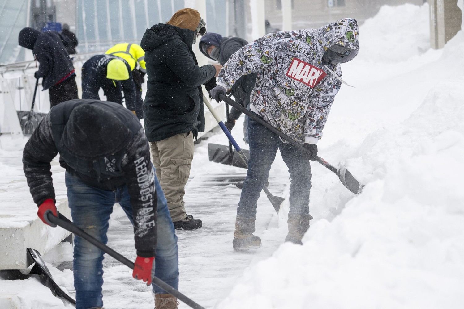 Workers clear a sidewalk of snow in Des Moines, Iowa, on Jan. 13, 2024.Photographer: Jim Watson/AFP/Getty Images