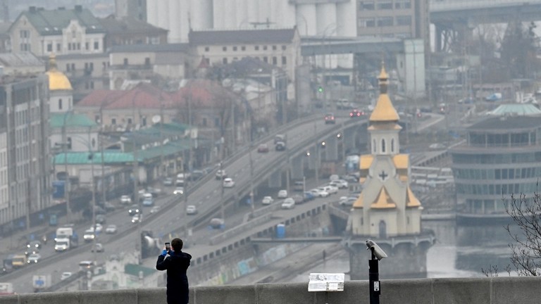 A boy takes a picture of the view in the Ukrainian capital of Kiev on March 16, 2023. ©  Sergei SUPINSKY / AFP