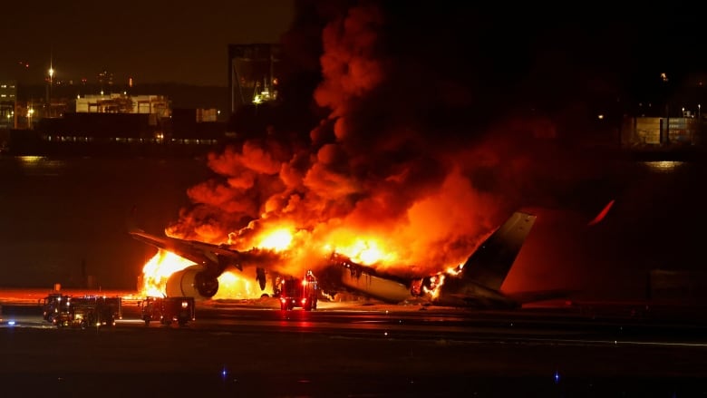 A Japan Airlines' A350 airplane burns at Haneda Airport in Tokyo, Japan, on Tuesday after colliding on the runway with another plane. (Issei Kato/Reuters)
