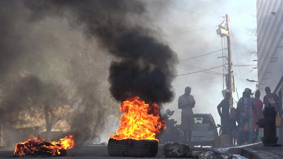 This screen grab taken from AFPTV shows tires on fire near the main prison of Port-au-Prince, Haiti, on March 3, 2024. © Jean Luckenson, AFP
